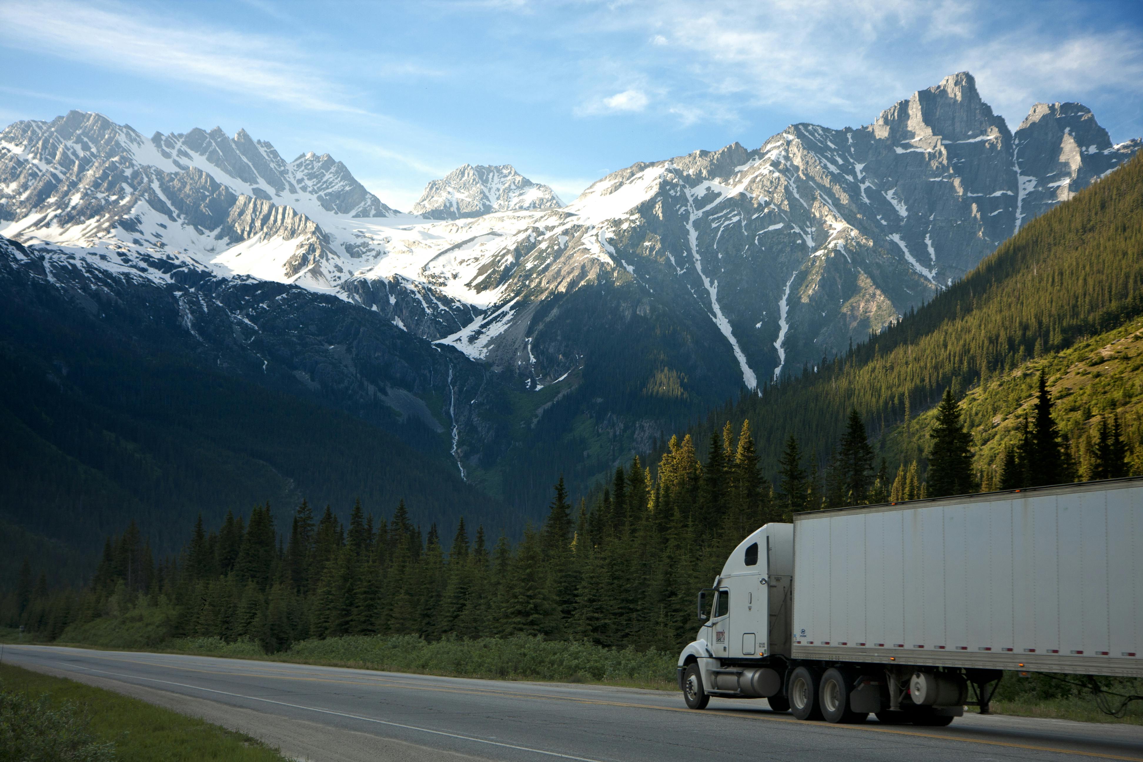 Aerial view of a truck on a winding forest road